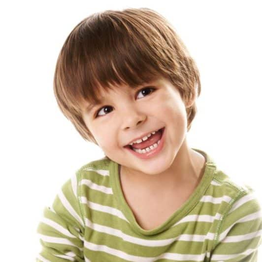 boy in green striped shirt shows child's teeth