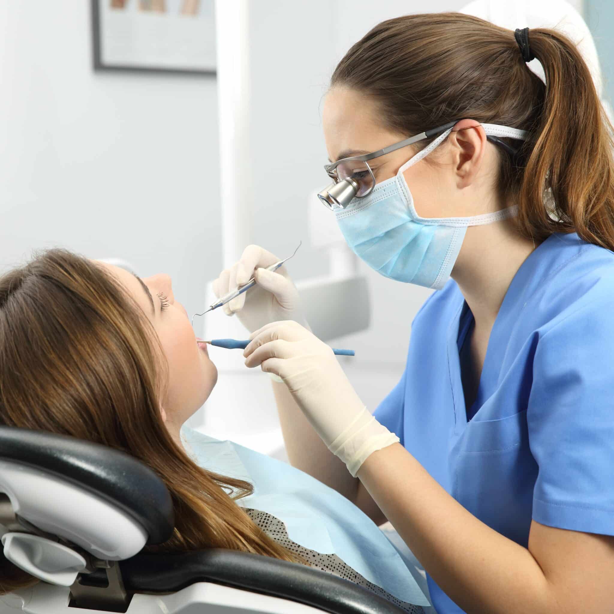 woman dentist examining patient referral